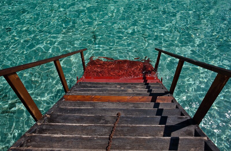 Wooden stairs to turquoise water