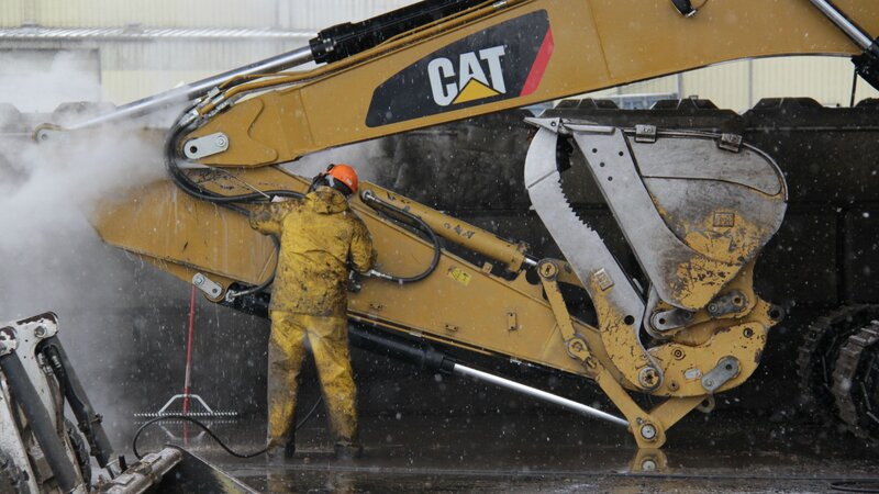 Worker Cleaning Excavator