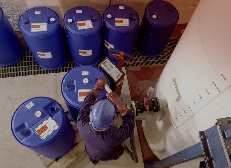 Worker handling chemical barrels