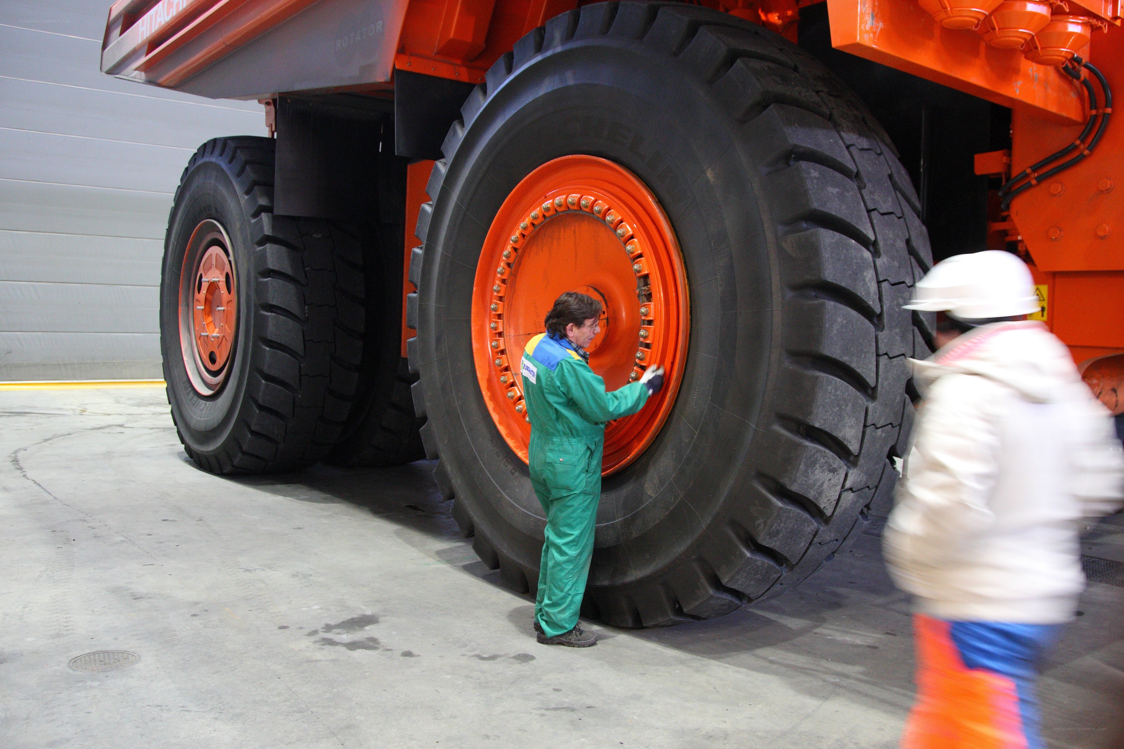 Worker inspecting large mining truck tire