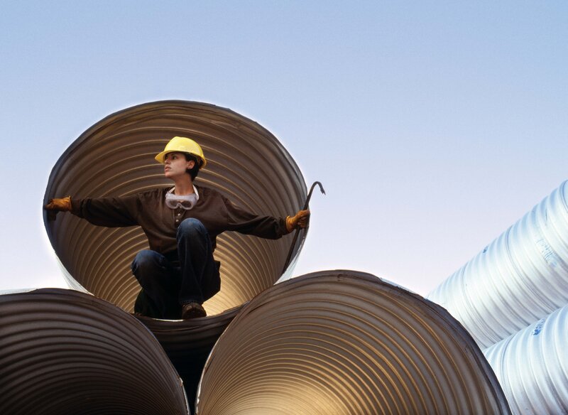 Worker on corrugated pipes