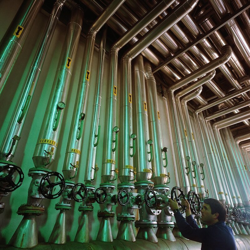 Worker operating valves in industrial plant