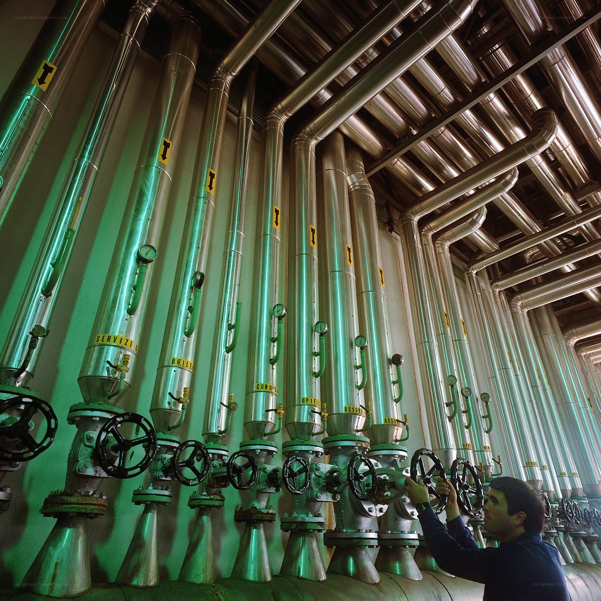 Worker operating valves in industrial plant