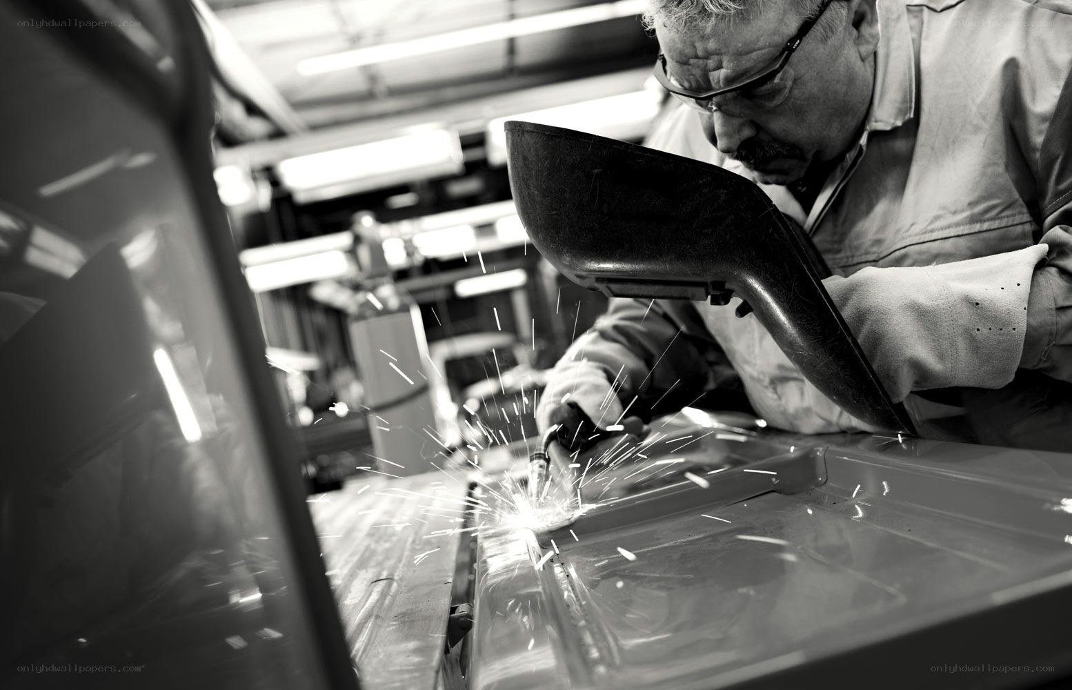 Worker welding car parts