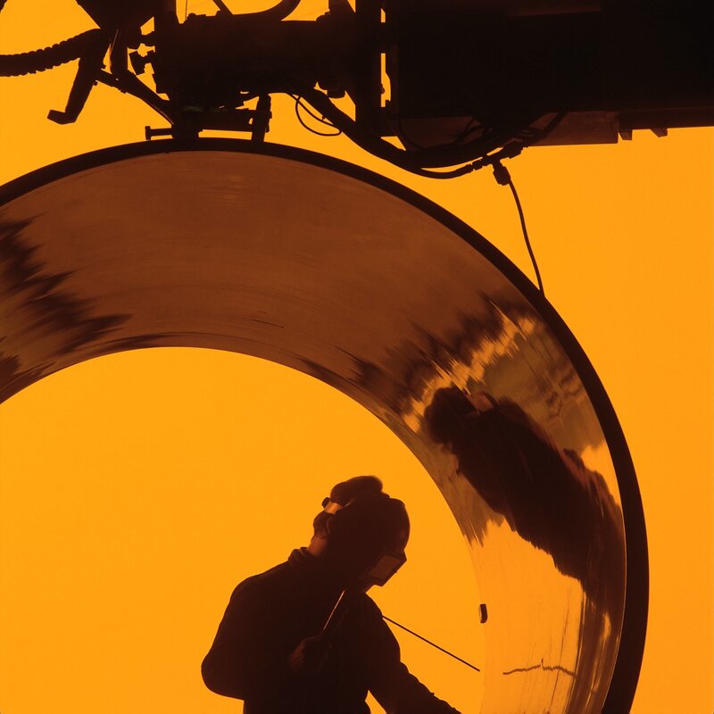 Worker welding large pipe