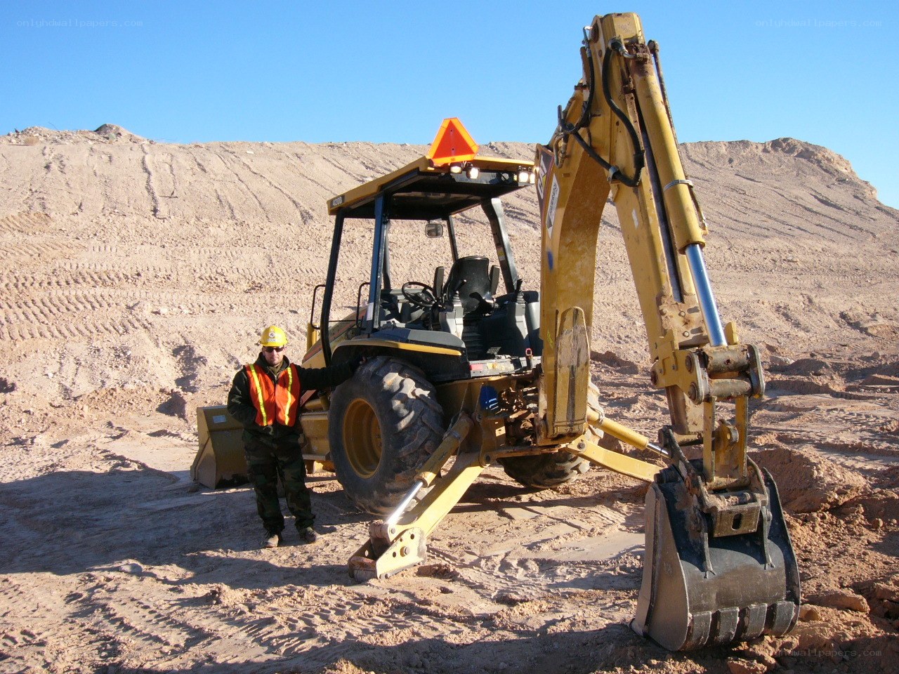 Worker with excavator at construction site