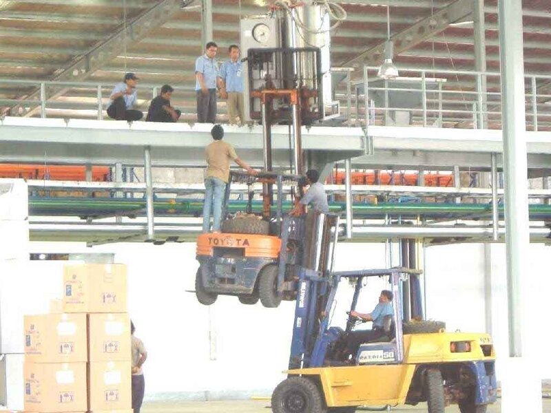 Workers on forklifts in warehouse