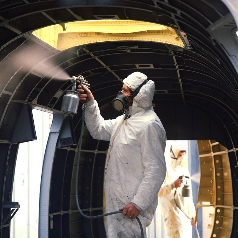 Workers painting aircraft interior