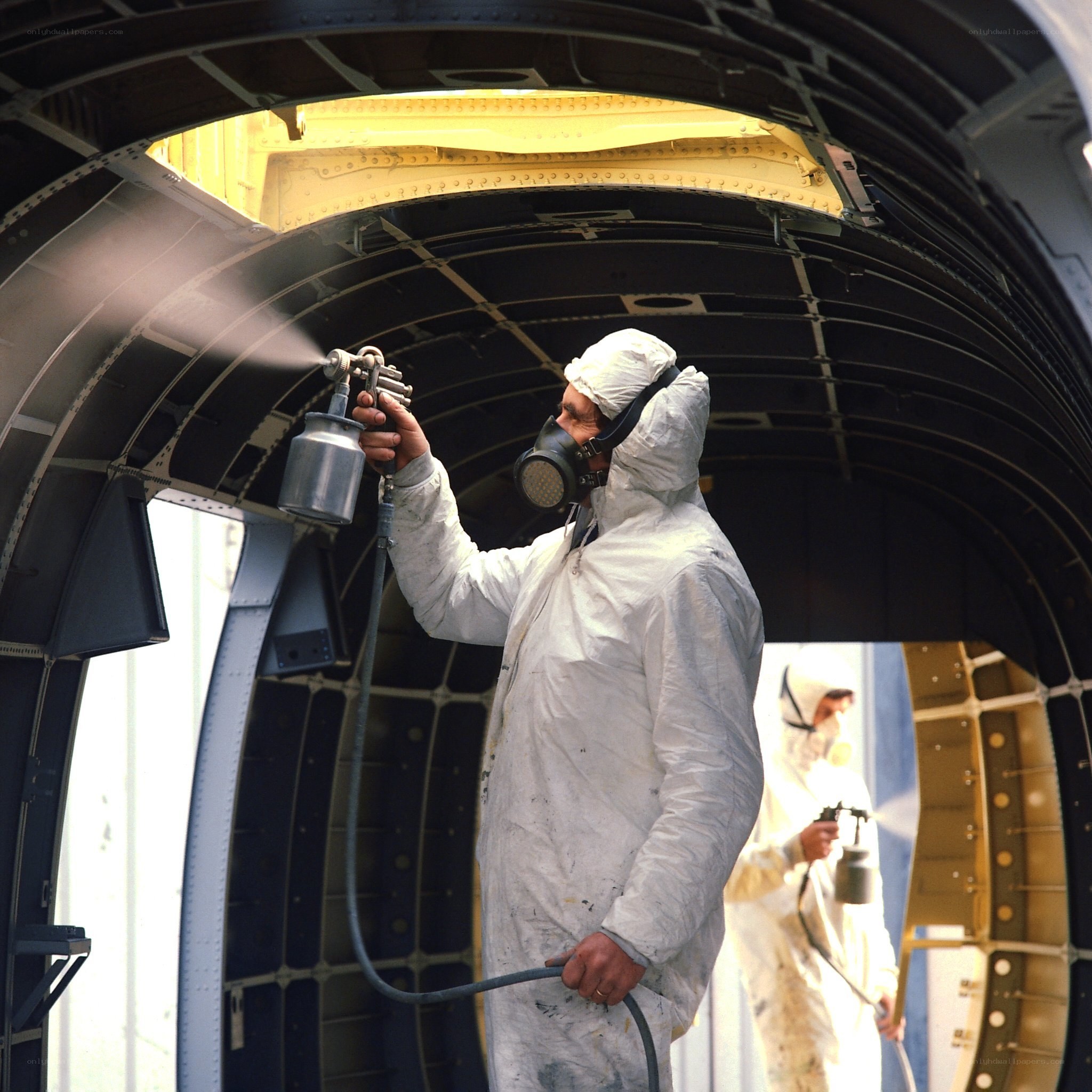 Workers painting aircraft interior