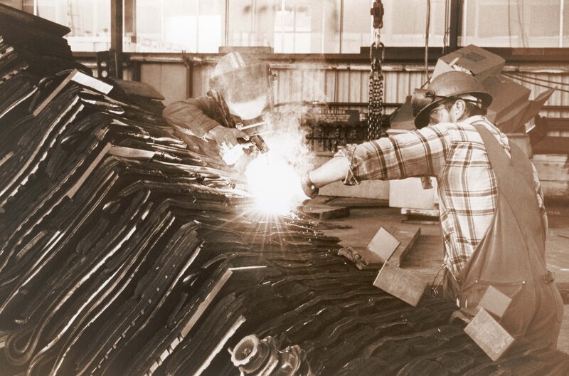 Workers welding metal sheets