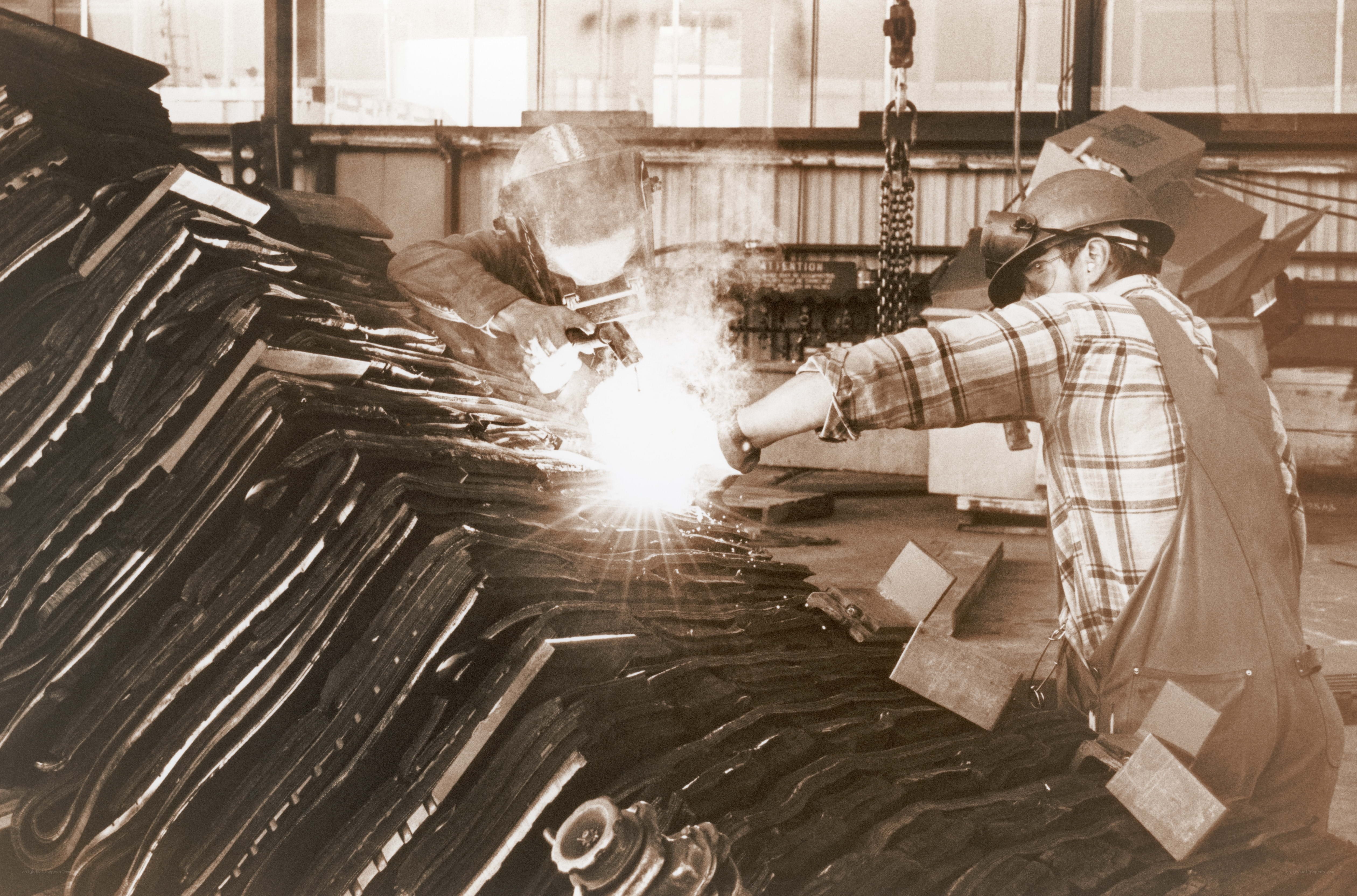 Workers welding metal sheets