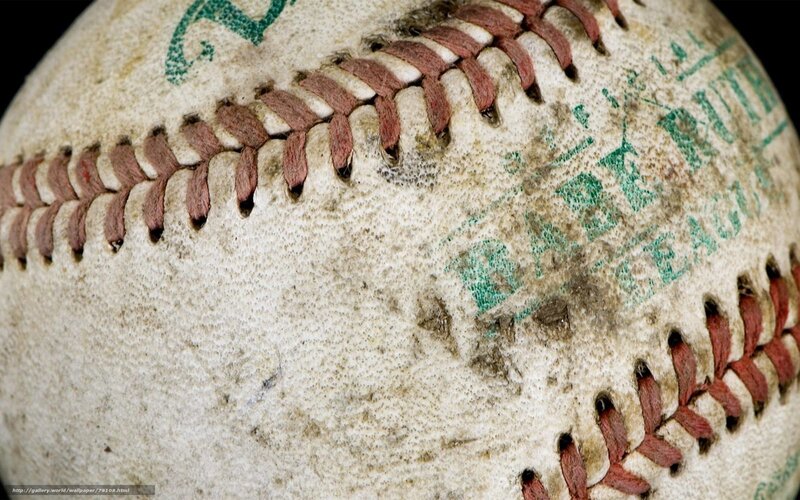 Worn baseball with green text