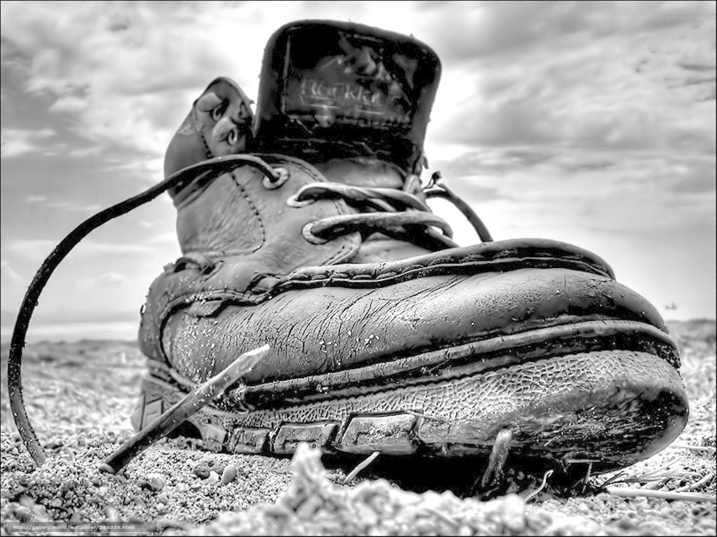 Worn boot on sandy ground