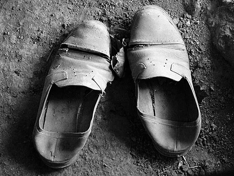 Worn shoes on dirt ground
