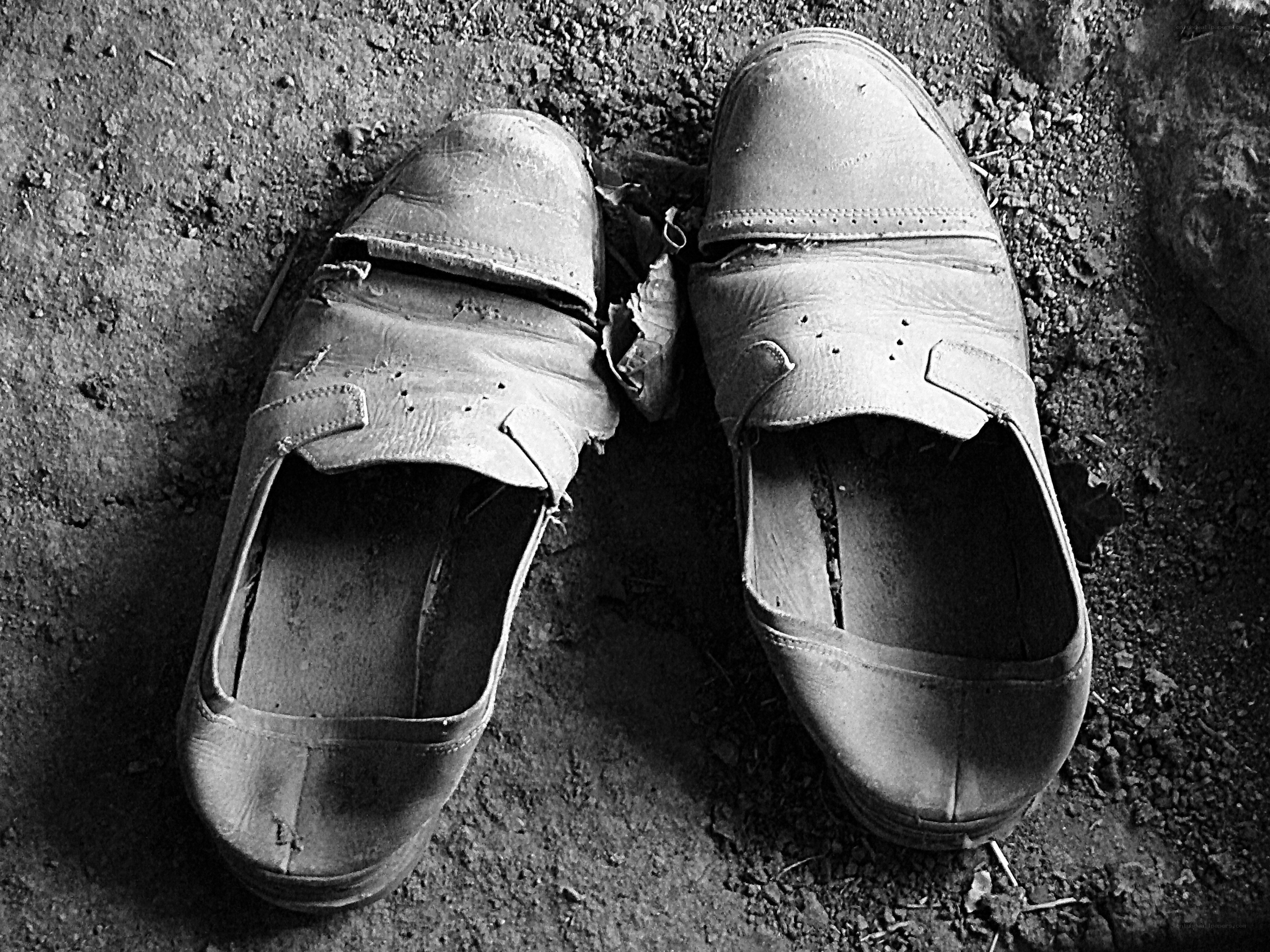 Worn shoes on dirt ground