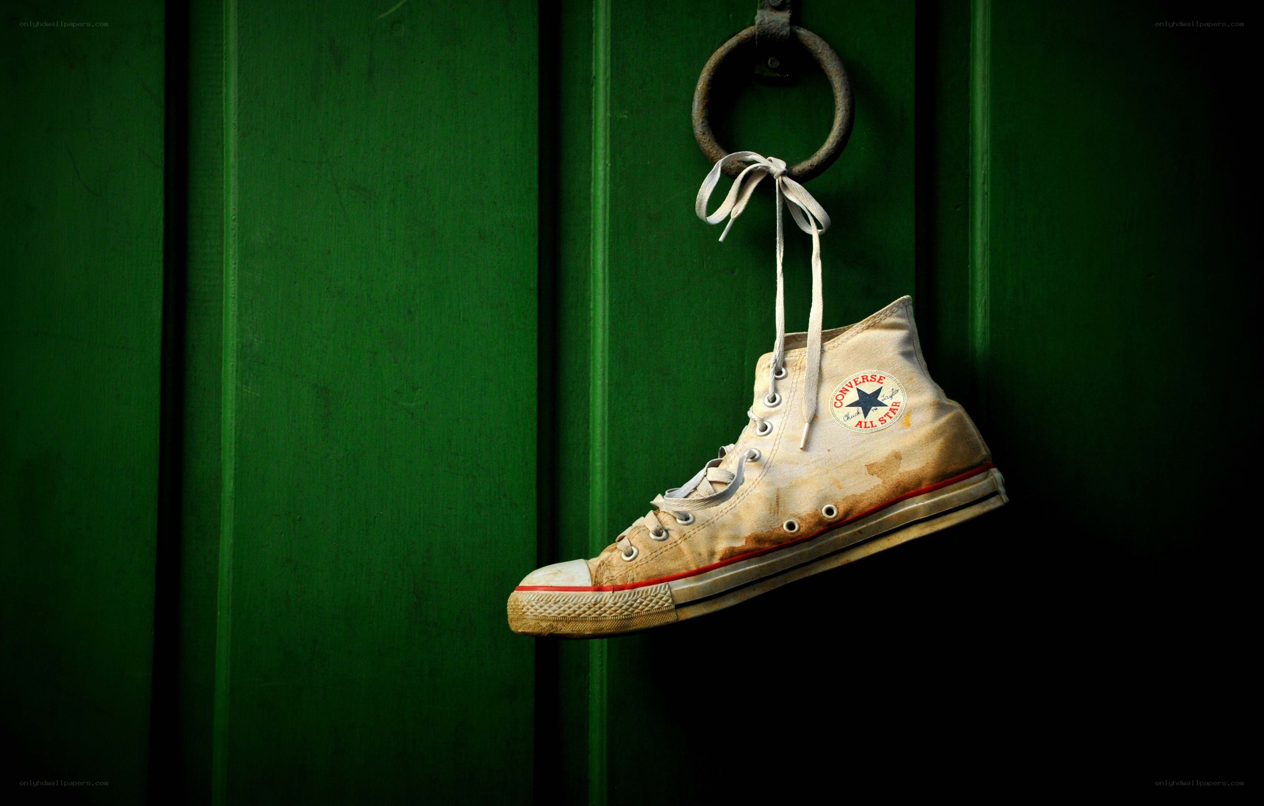 Worn sneaker hanging on green door