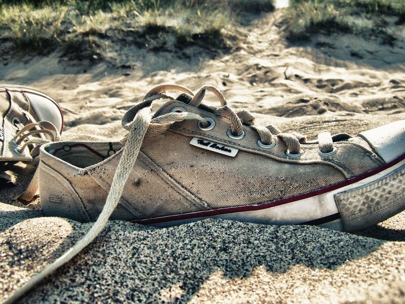 Worn Sneakers on Sand