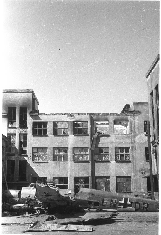 Wrecked plane in front of damaged building