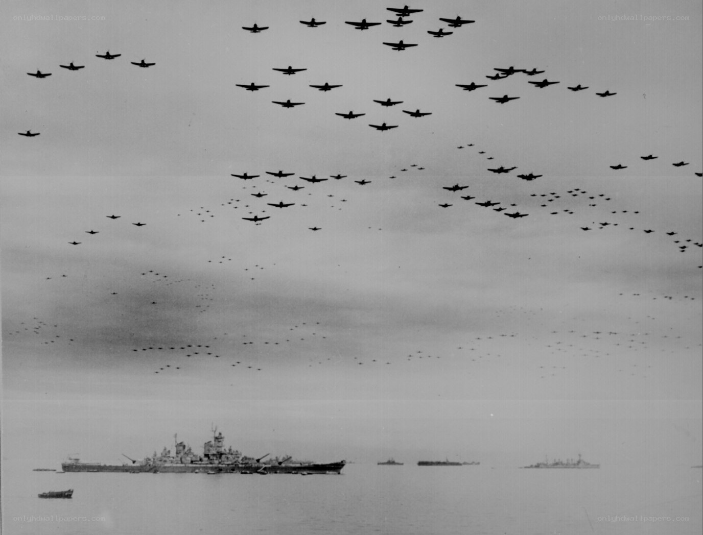 WWII aircraft formation over fleet