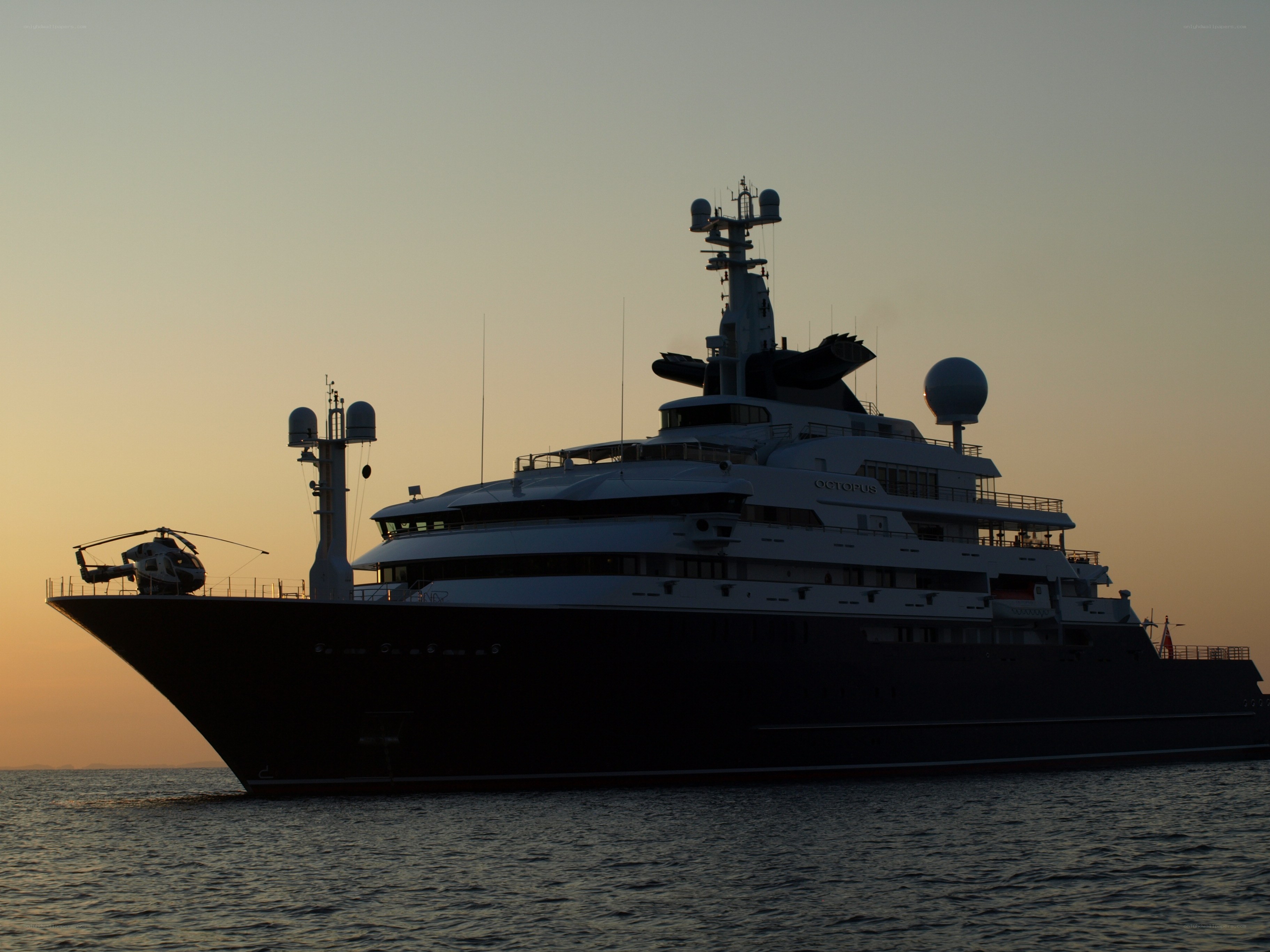 Yacht at sunset with helicopter