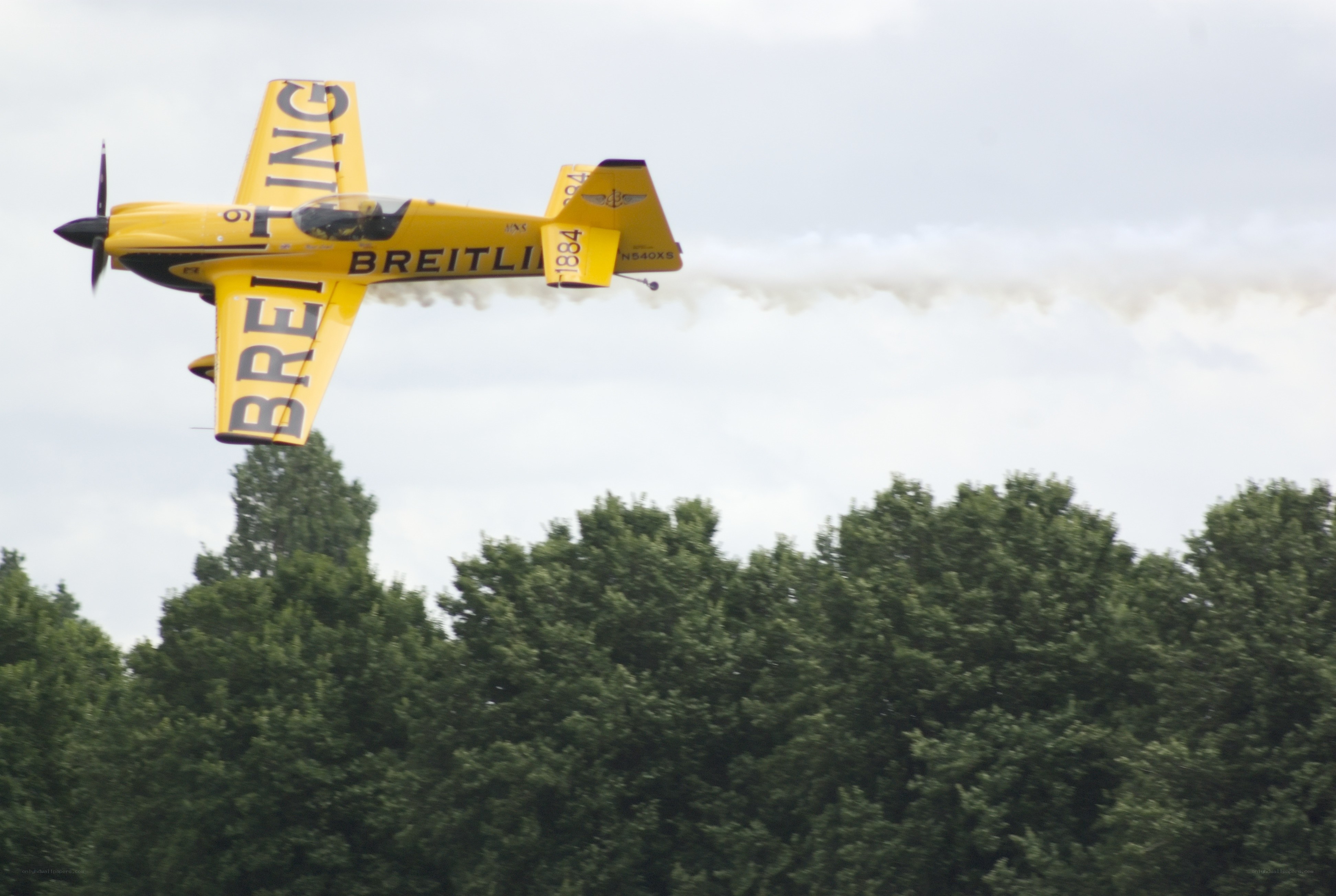 Yellow aerobatic plane in flight