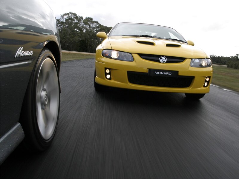 Yellow and black Monaro cars on track