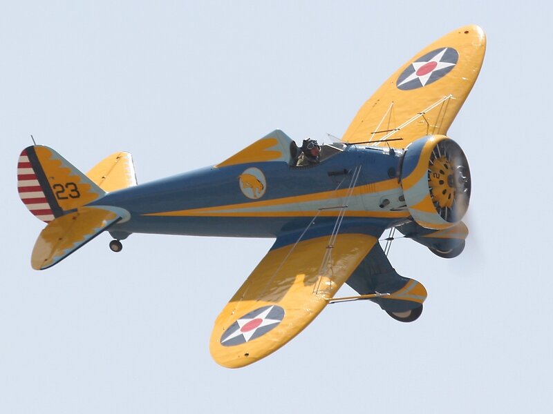 yellow and blue biplane in flight