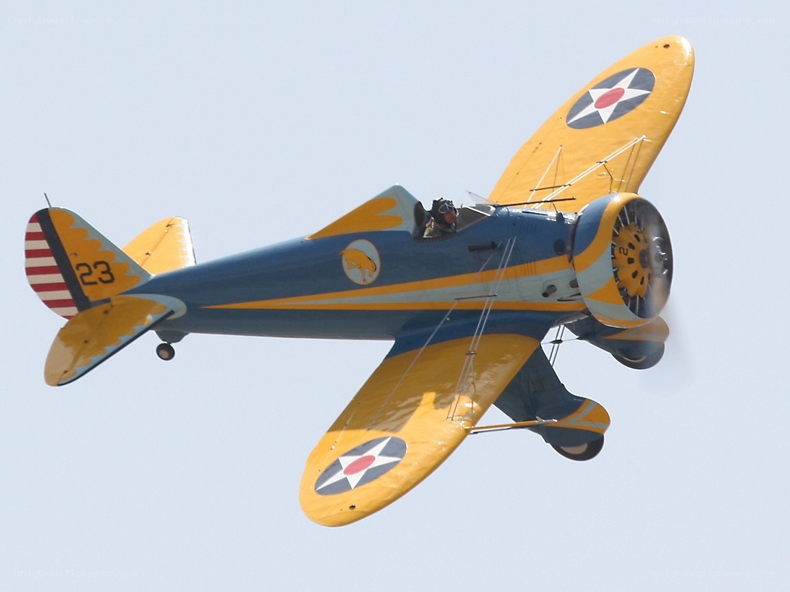yellow and blue biplane in flight