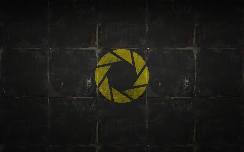 yellow aperture logo on dark wall