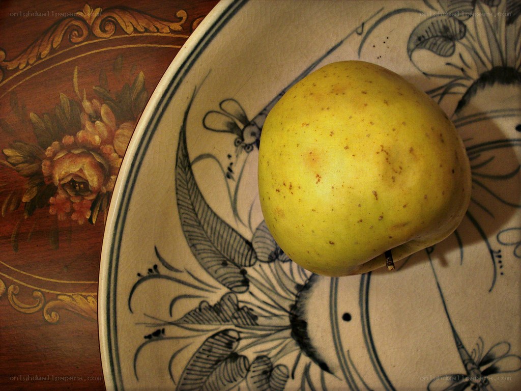 yellow apple on decorative plate