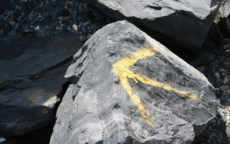 Yellow arrow painted on rock