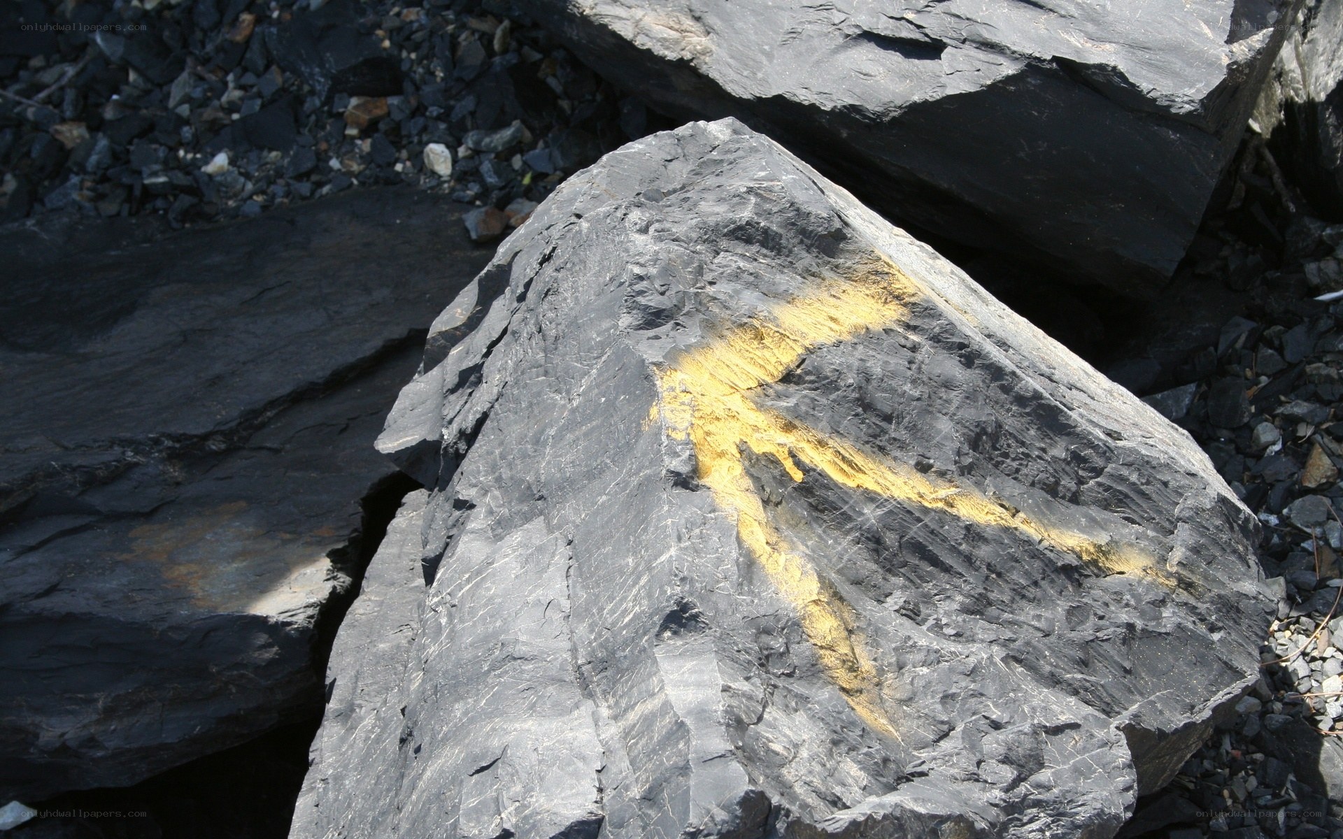 Yellow arrow painted on rock