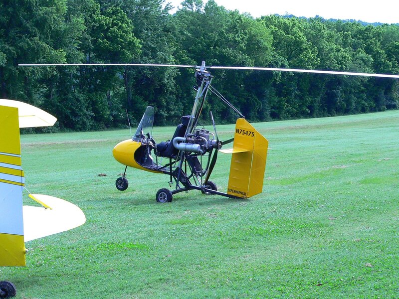 Yellow autogyro on grass field