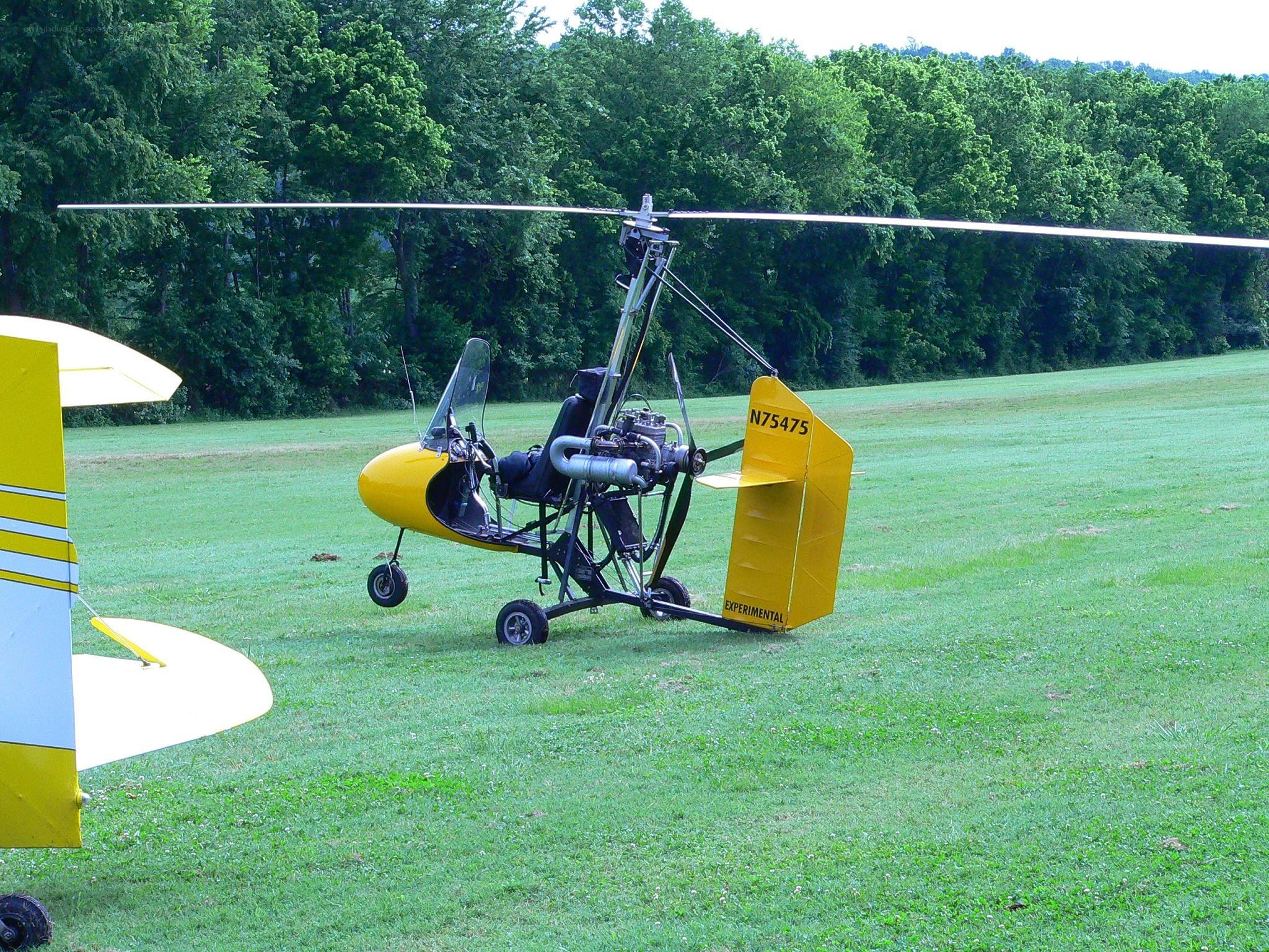 Yellow autogyro on grass field