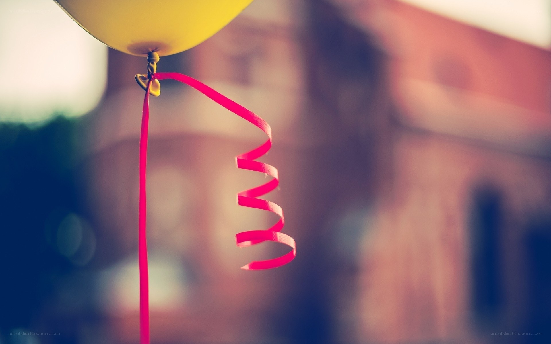 Yellow balloon with red ribbon
