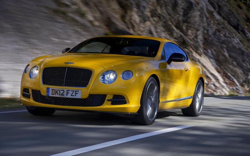 yellow bentley driving on road