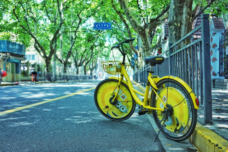 Yellow bike on a tree-lined street