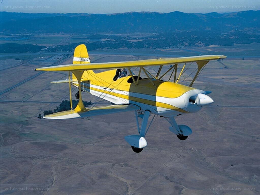 Yellow biplane in flight