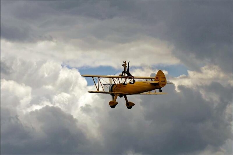 Yellow biplane in flight