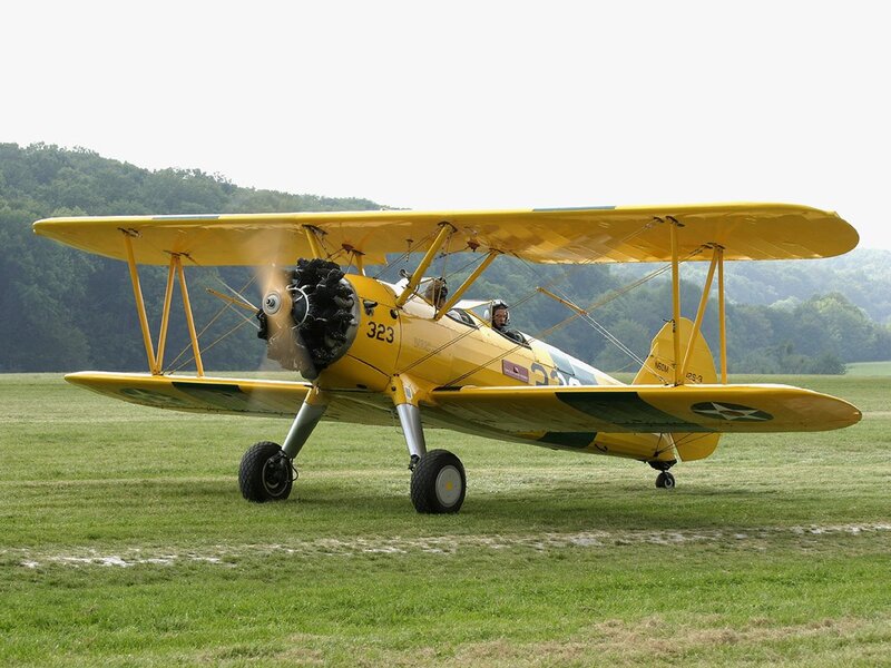 Yellow biplane on grass field