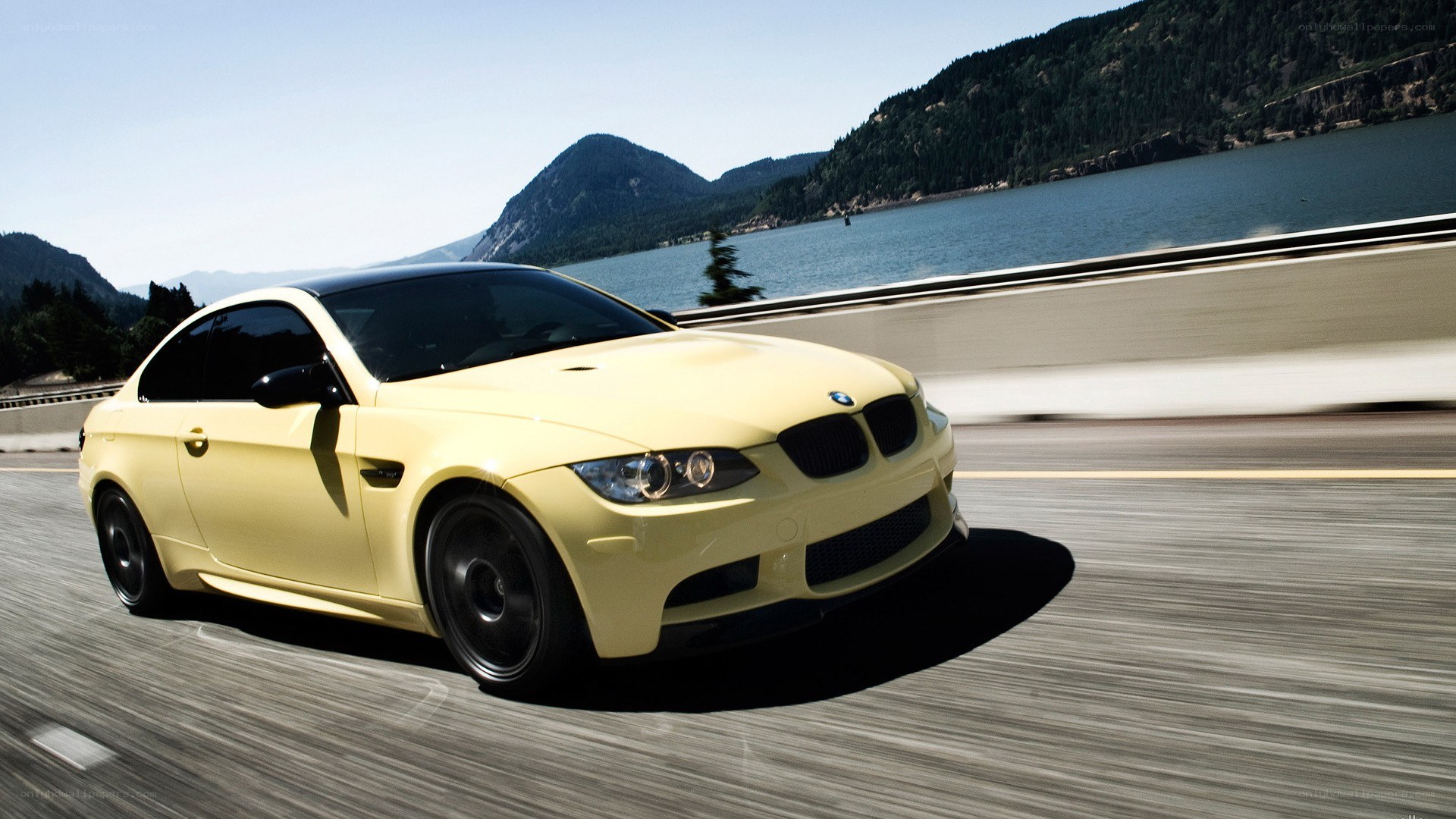 yellow BMW driving on a bridge