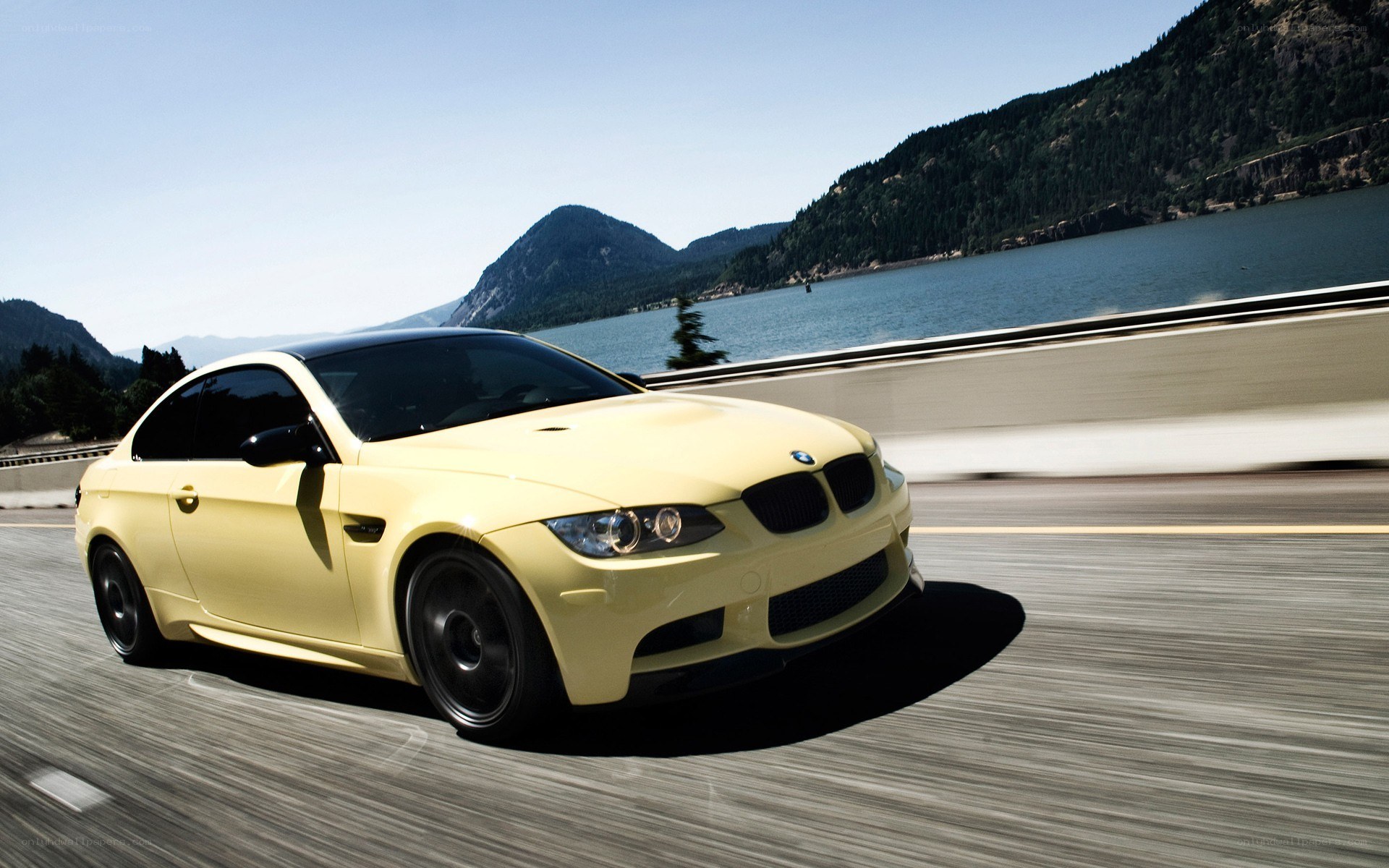 Yellow BMW driving on a bridge