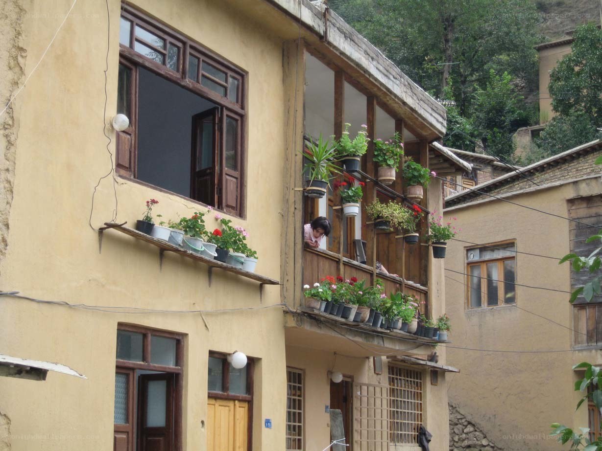 Yellow building with flower-filled balconies
