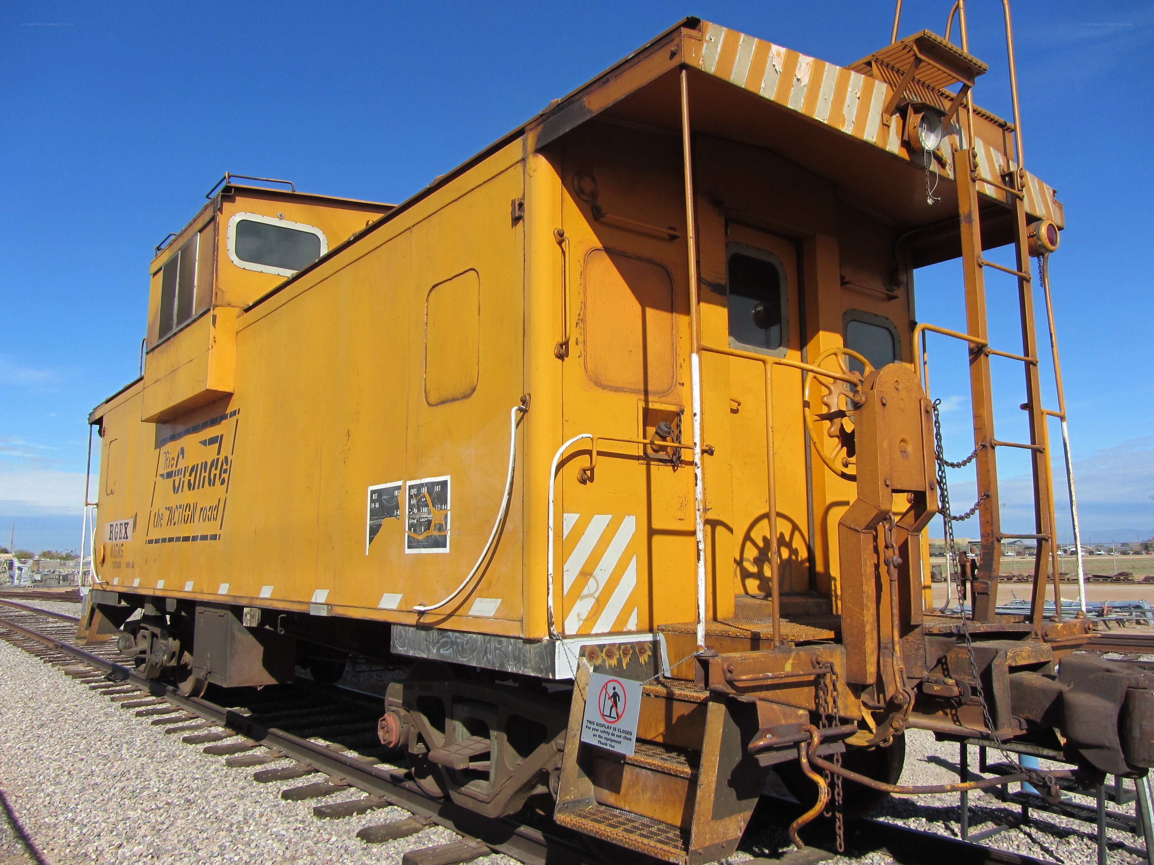 yellow caboose on train tracks