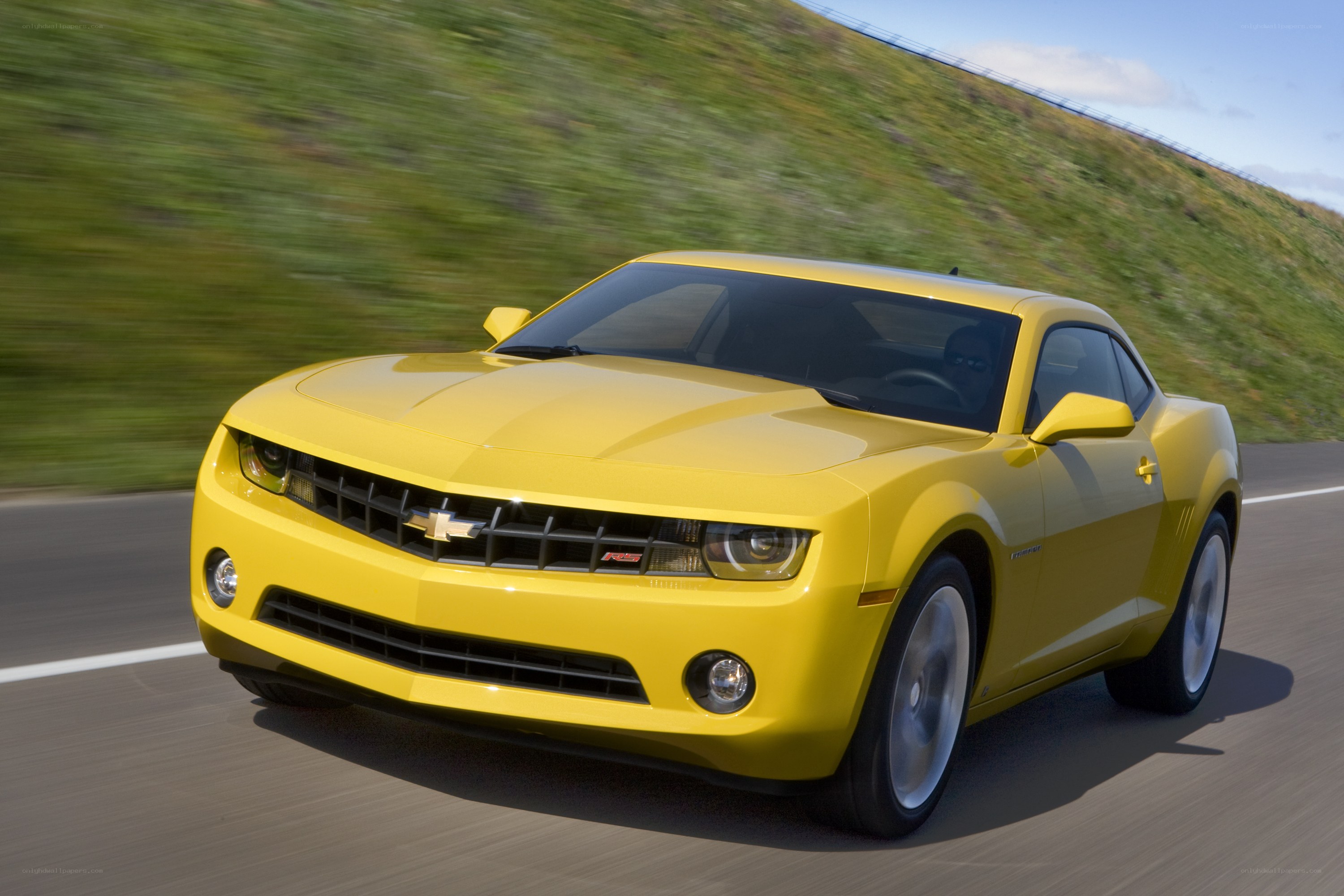 Yellow Camaro driving on road