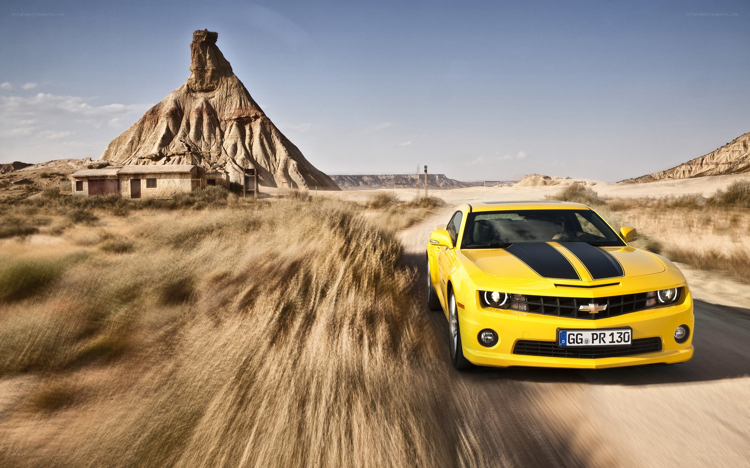 Yellow Camaro in desert landscape