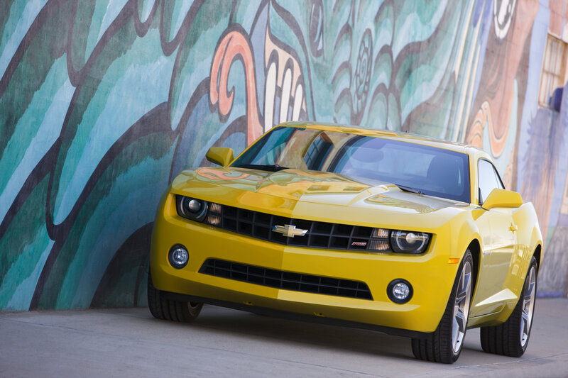 Yellow Camaro in front of mural