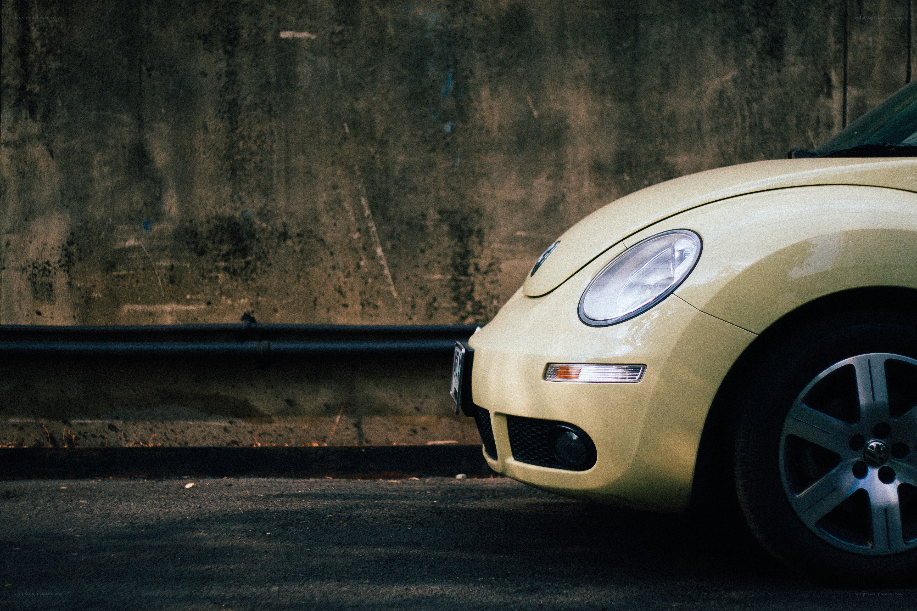 yellow car against concrete wall