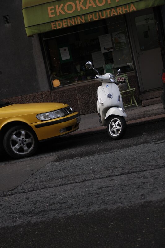 Yellow car and white scooter on street