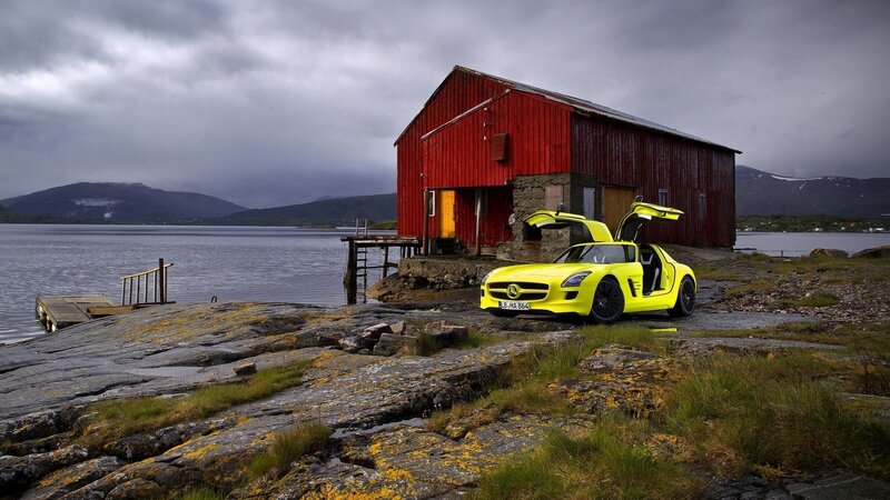 Yellow car by red barn